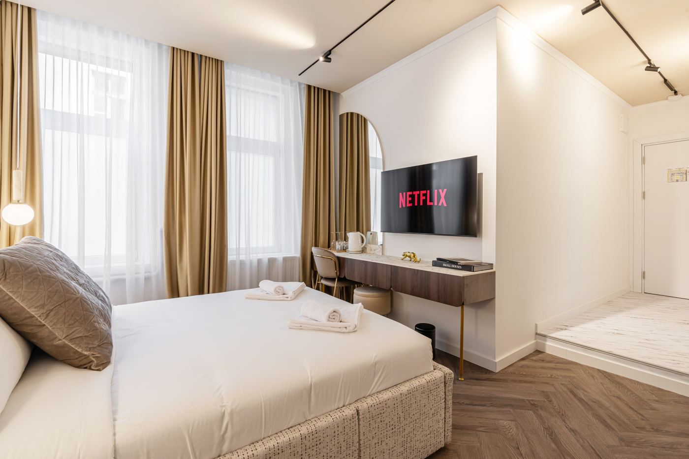 Double room with tall windows and gold curtains